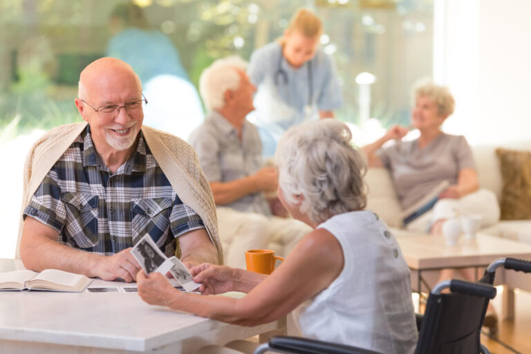 Married couple of elders sitting together and watching old photos at the nursing home