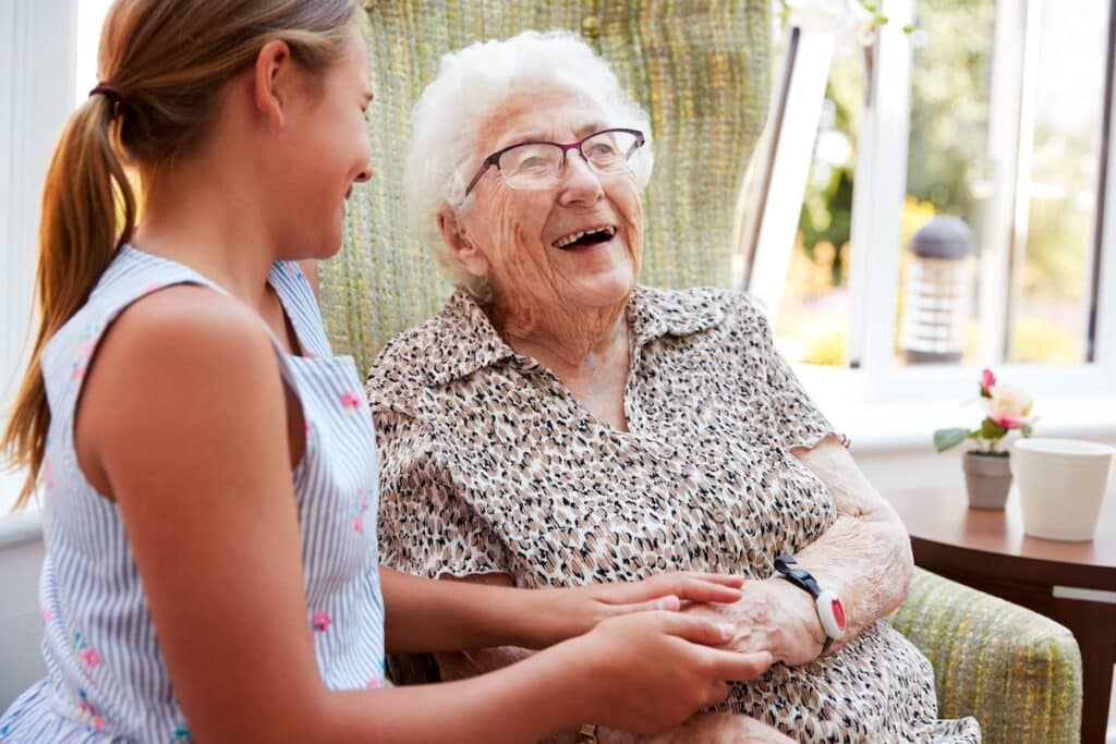 Happy older woman holding hands with granddaughter
