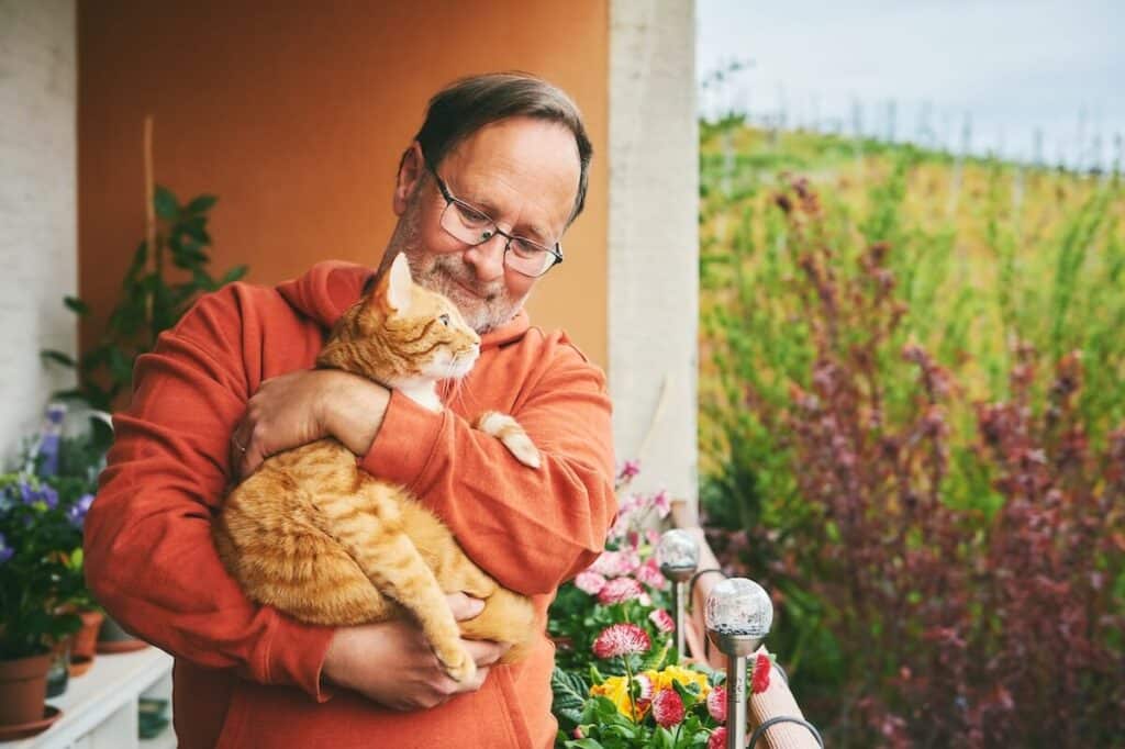 Older adult holding a kitten in his arms
