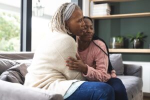 Older woman hugging her daughter at home