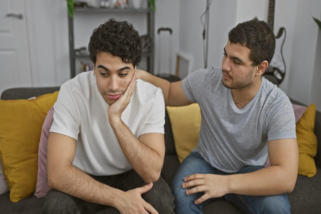 An adult man comforting his sibling