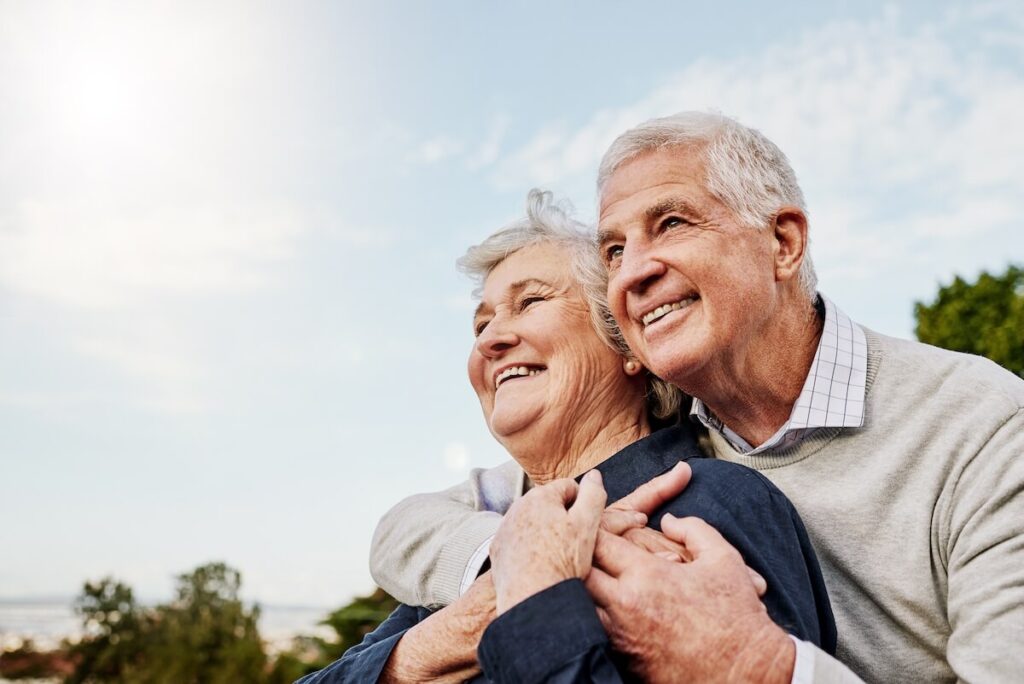 Senior couple smiling and looking at open sky
