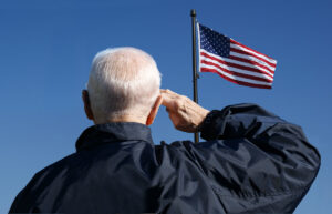 Veteran saluting an American flag