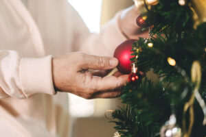 Older adult decorating a Christmas tree