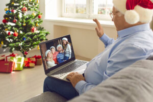 Older adult having a video call with his family through his laptop